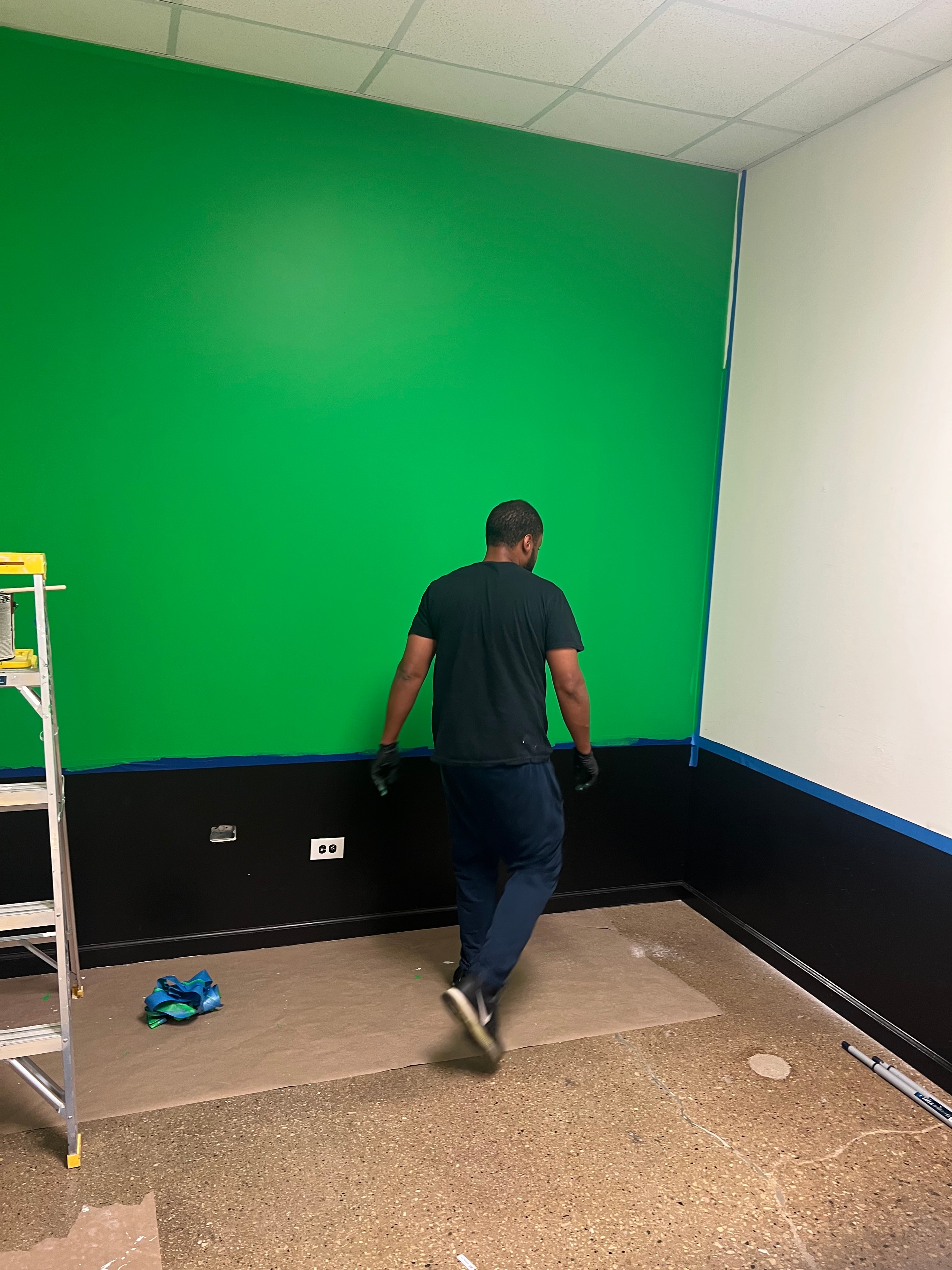 Volunteer painting the green screen room